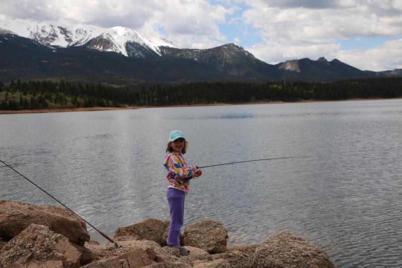 An angler smiles for the camera while fishing the scenic North Slope Lakes